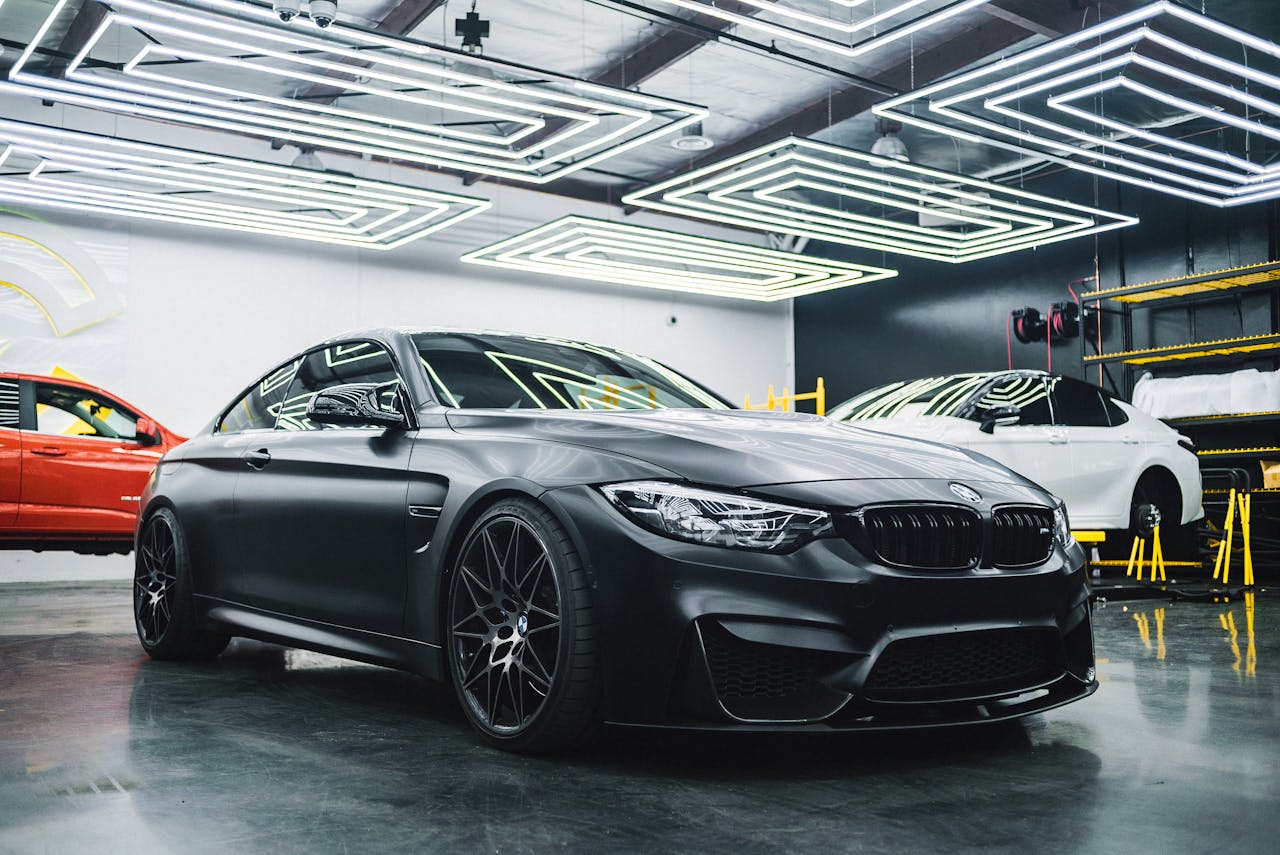Services Luxury black car showcased in a modern garage setting, highlighting its sleek design and elegance.