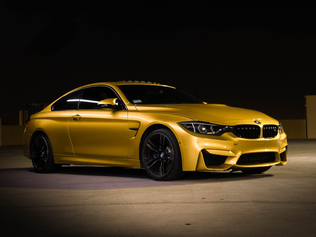 Services Elegant yellow BMW sports car photographed at night, showcasing sleek design and luxury appeal.